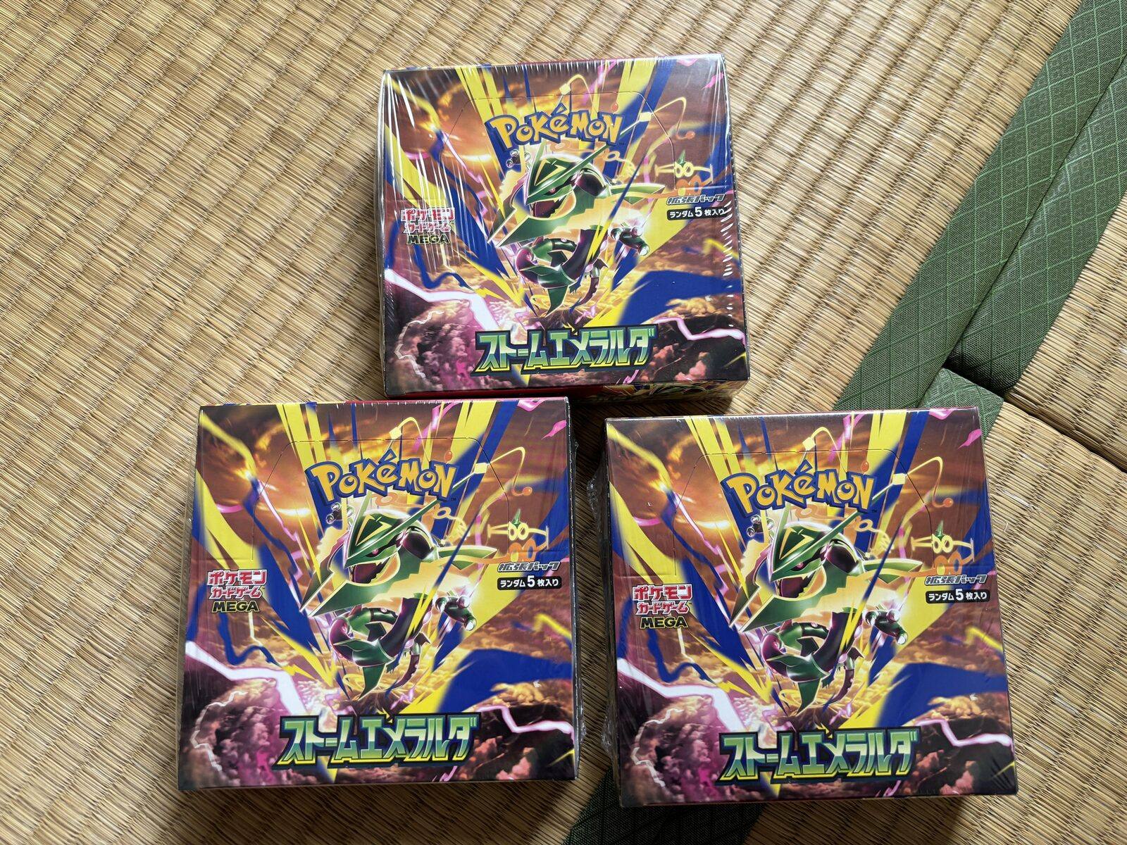 Three sealed Storm Emerald booster boxes photographed by Akina